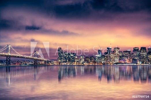 Picture of San Francisco California skyline with lights and bay under colorful sunset sky